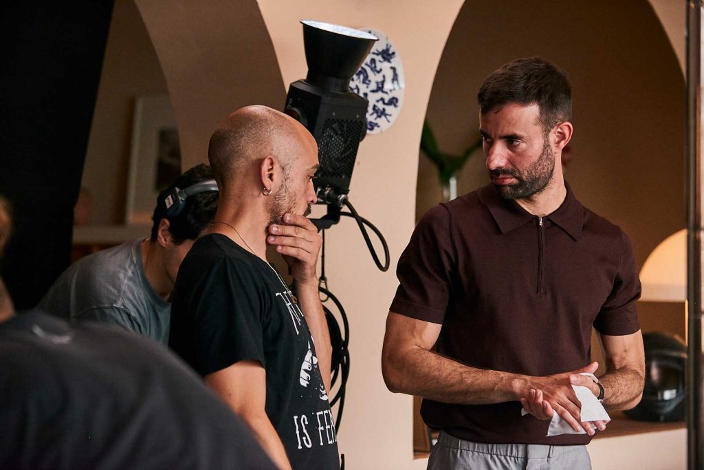 Queer cinema behind the scenes image of director speaking with crew beside studio lighting on set